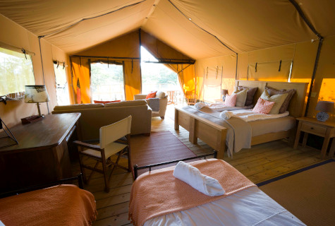 Interior photograph of Le Camp's penthouse safari tent, Mount Kenya. Beautiful handmade solid wook furniture, crisp white sheets, the ultimate luxury outdoor holiday. Glamping South West France.